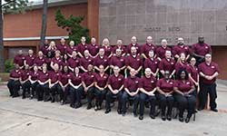 Image: Class #26 grouped in front of red brick building.