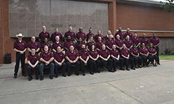 Image: Class #42 grouped in front of red brick building.