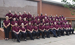 Image: Class #46 grouped in front of red brick building.