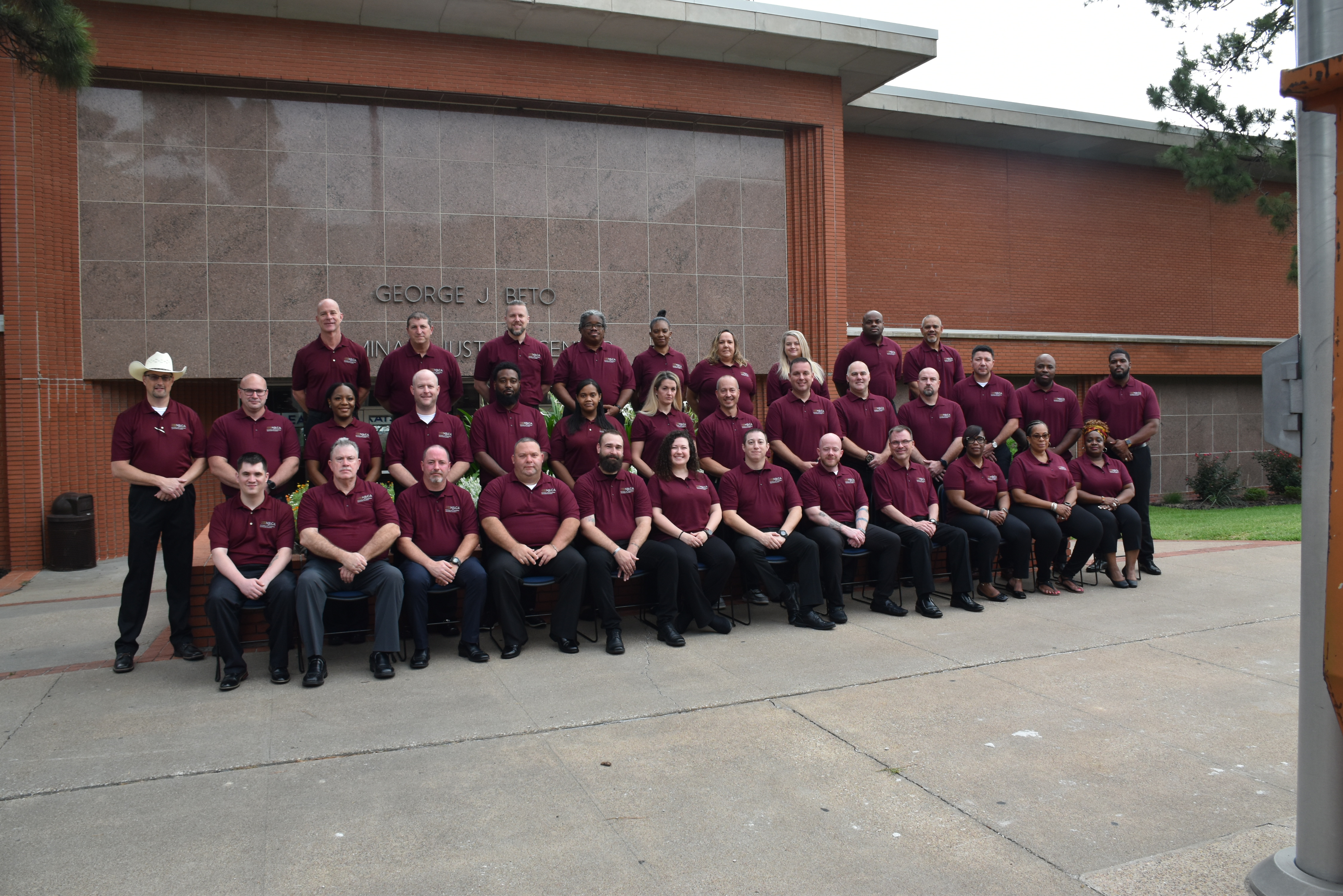 Image: Class #42 grouped outside a red brick building.