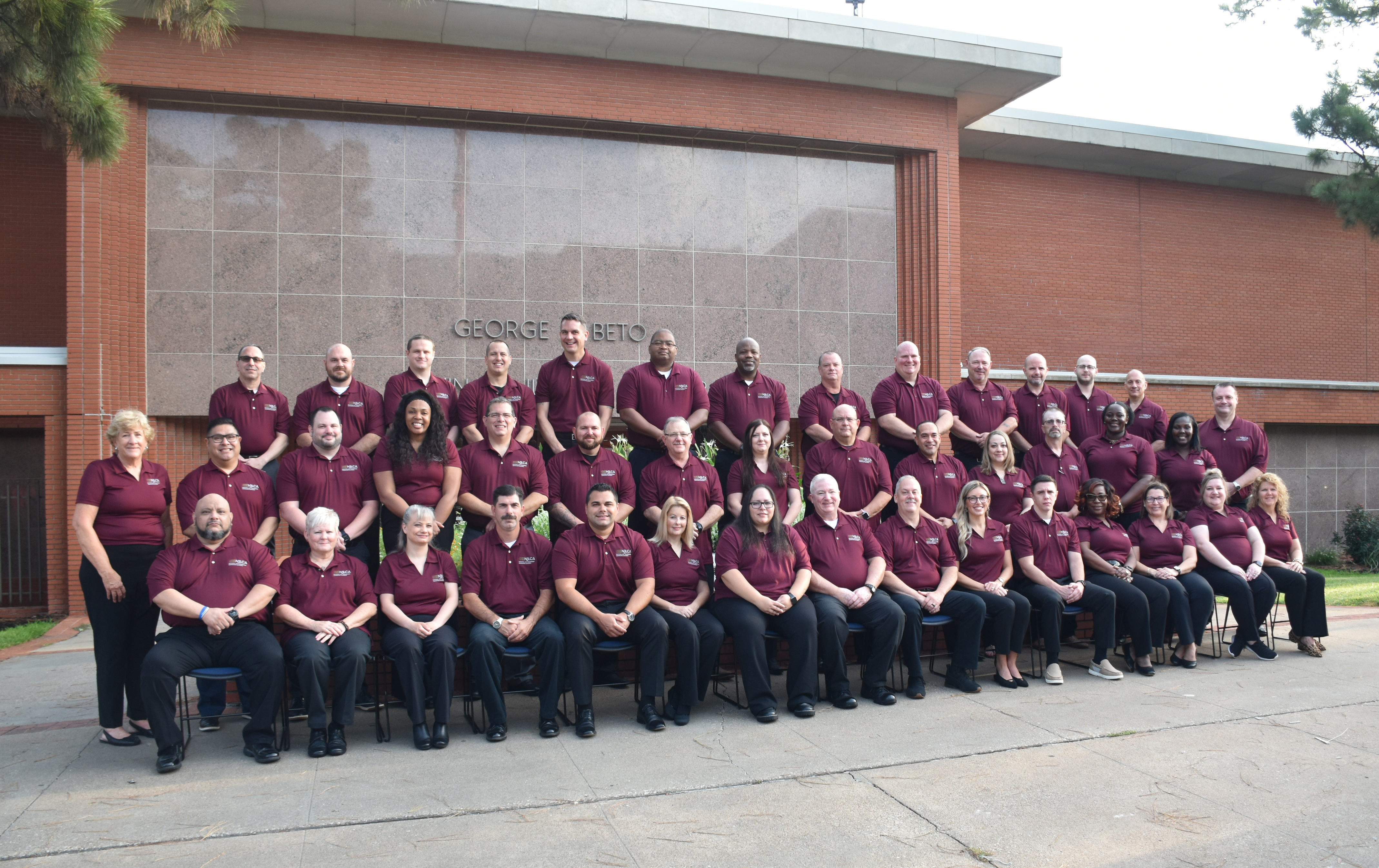 Image: Class #43 grouped outside a red brick building.