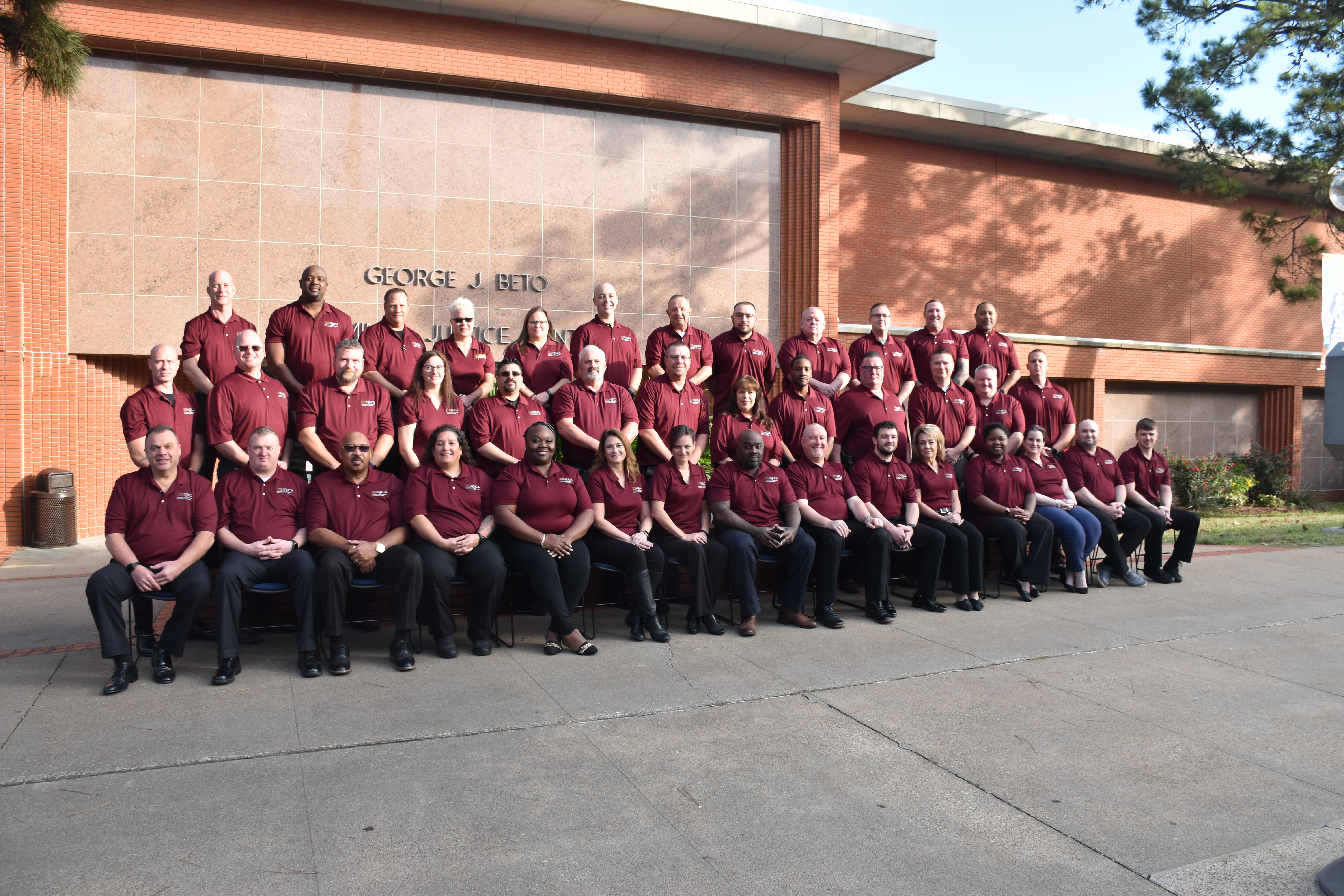 Image: Class #44 grouped outside a red brick building.