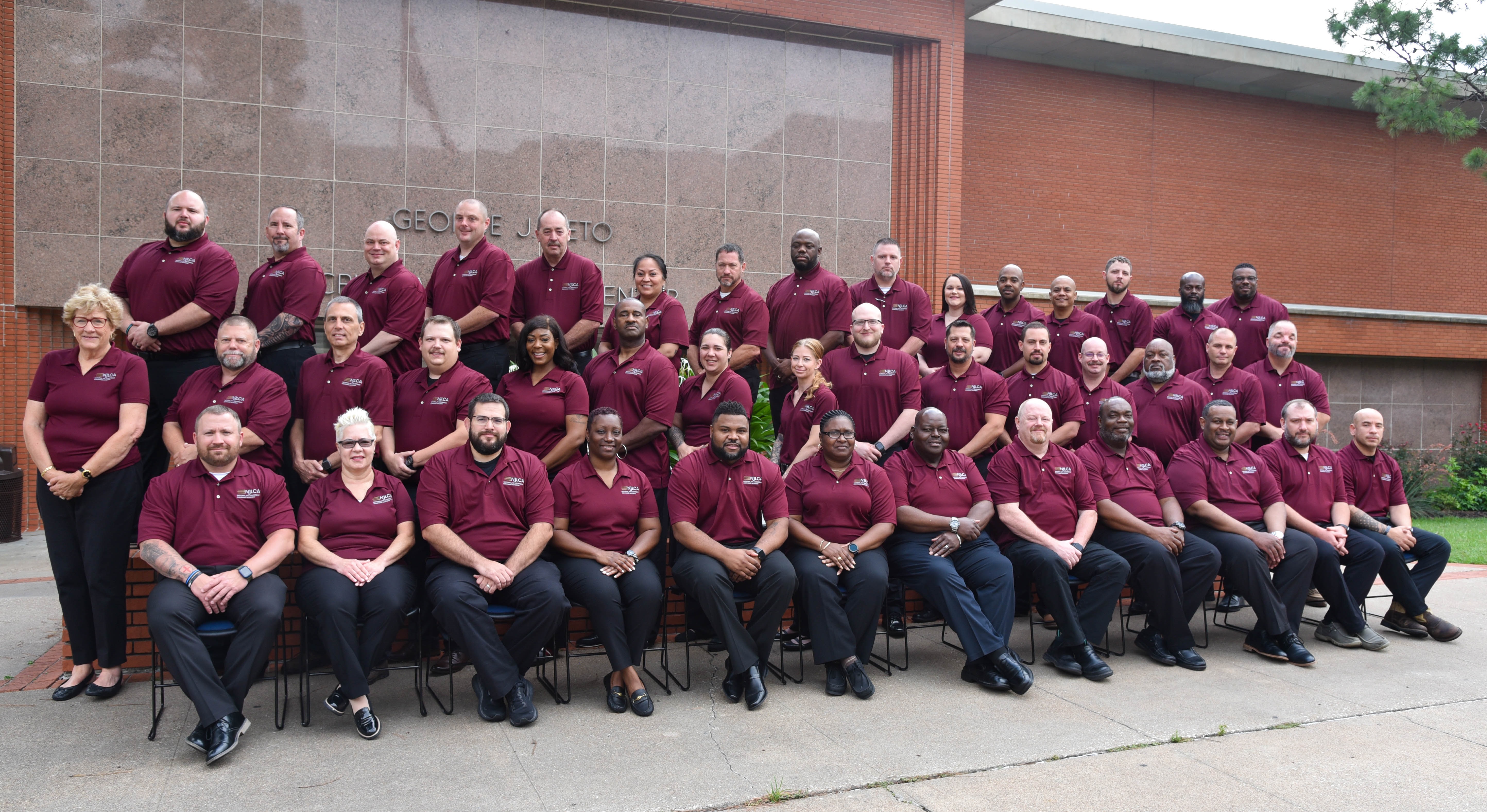 Image: Class #46 grouped outside a red brick building.
