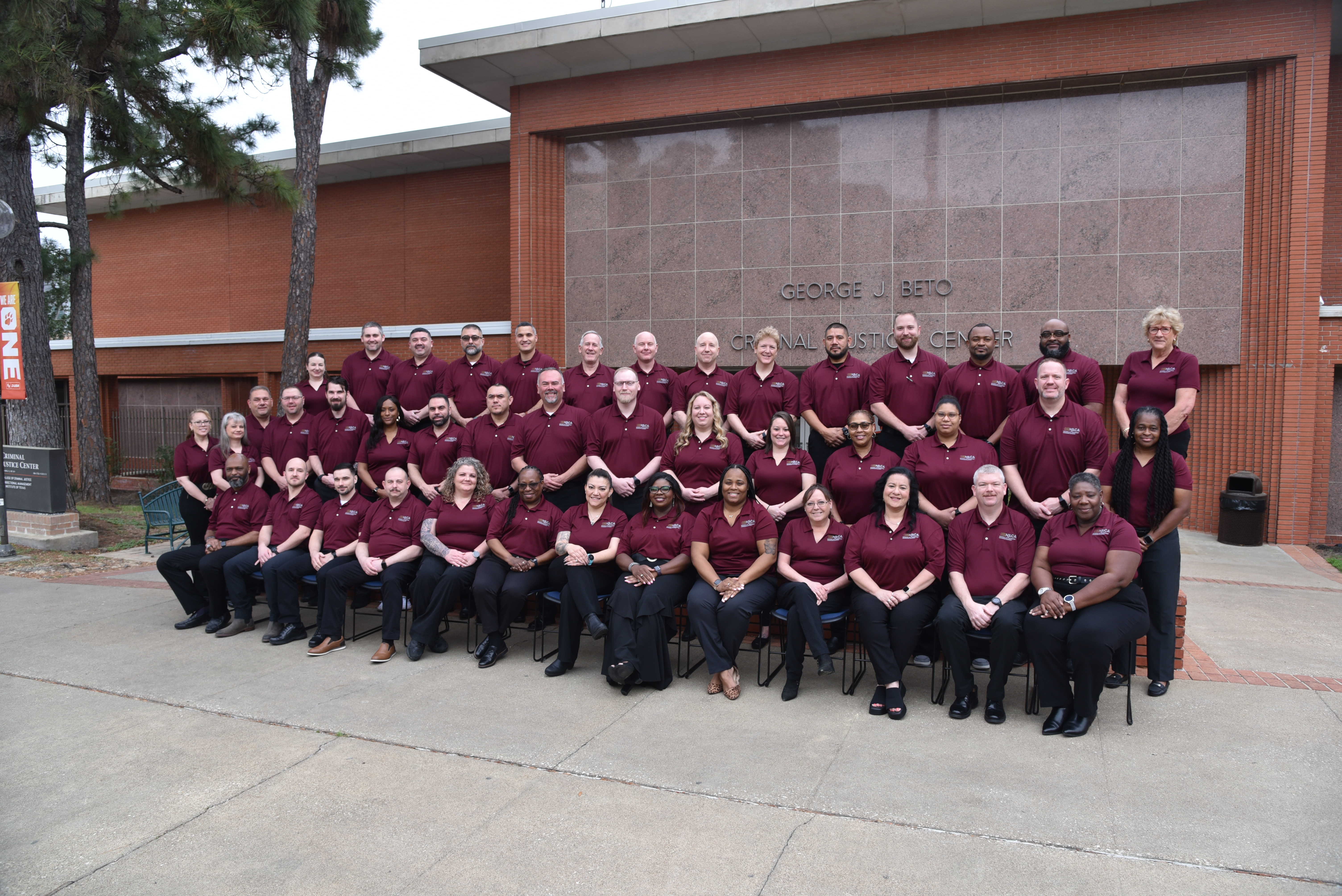 Image: Class #49 grouped outside a red brick building.
