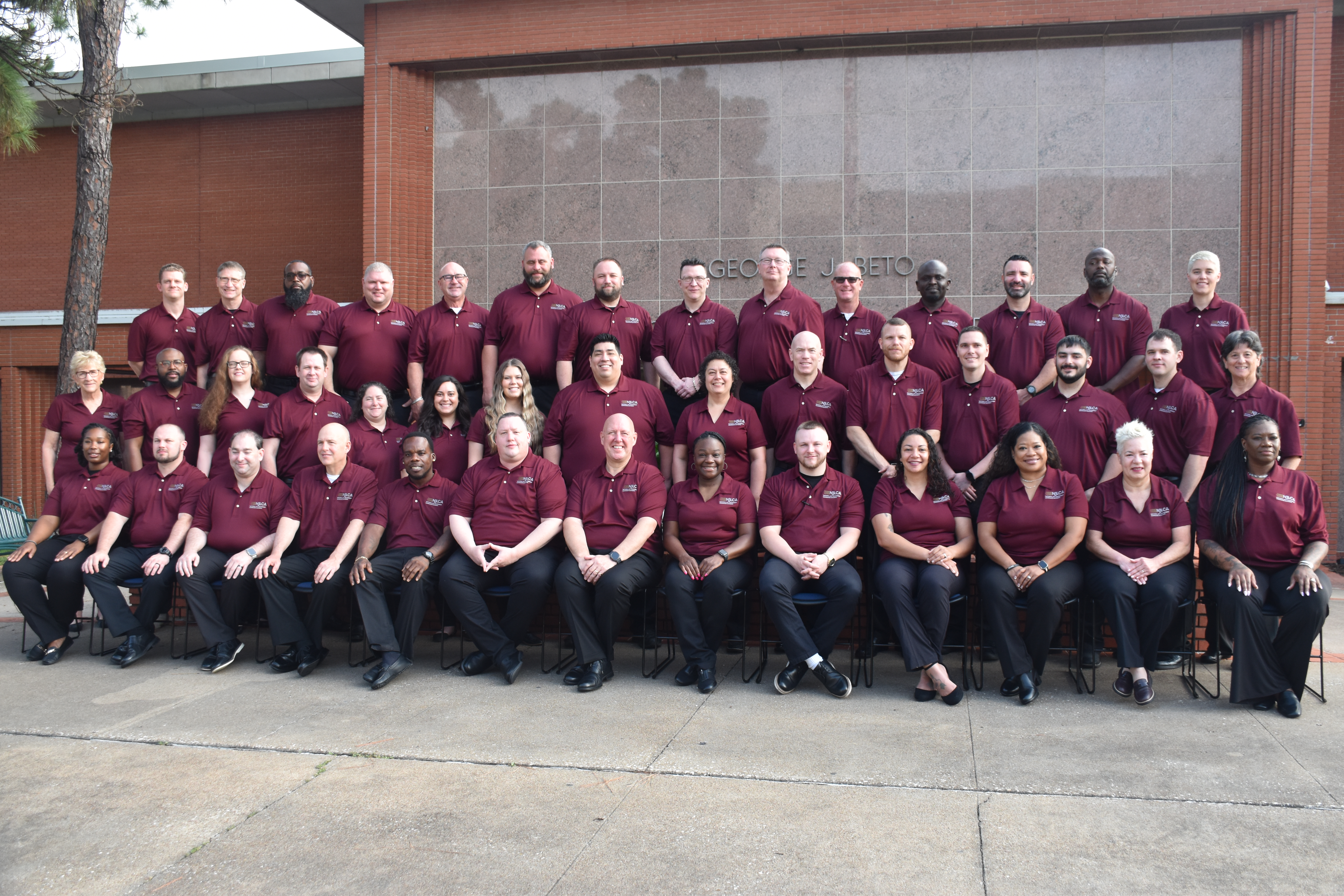 Image: Class #53 grouped outside a red brick building.