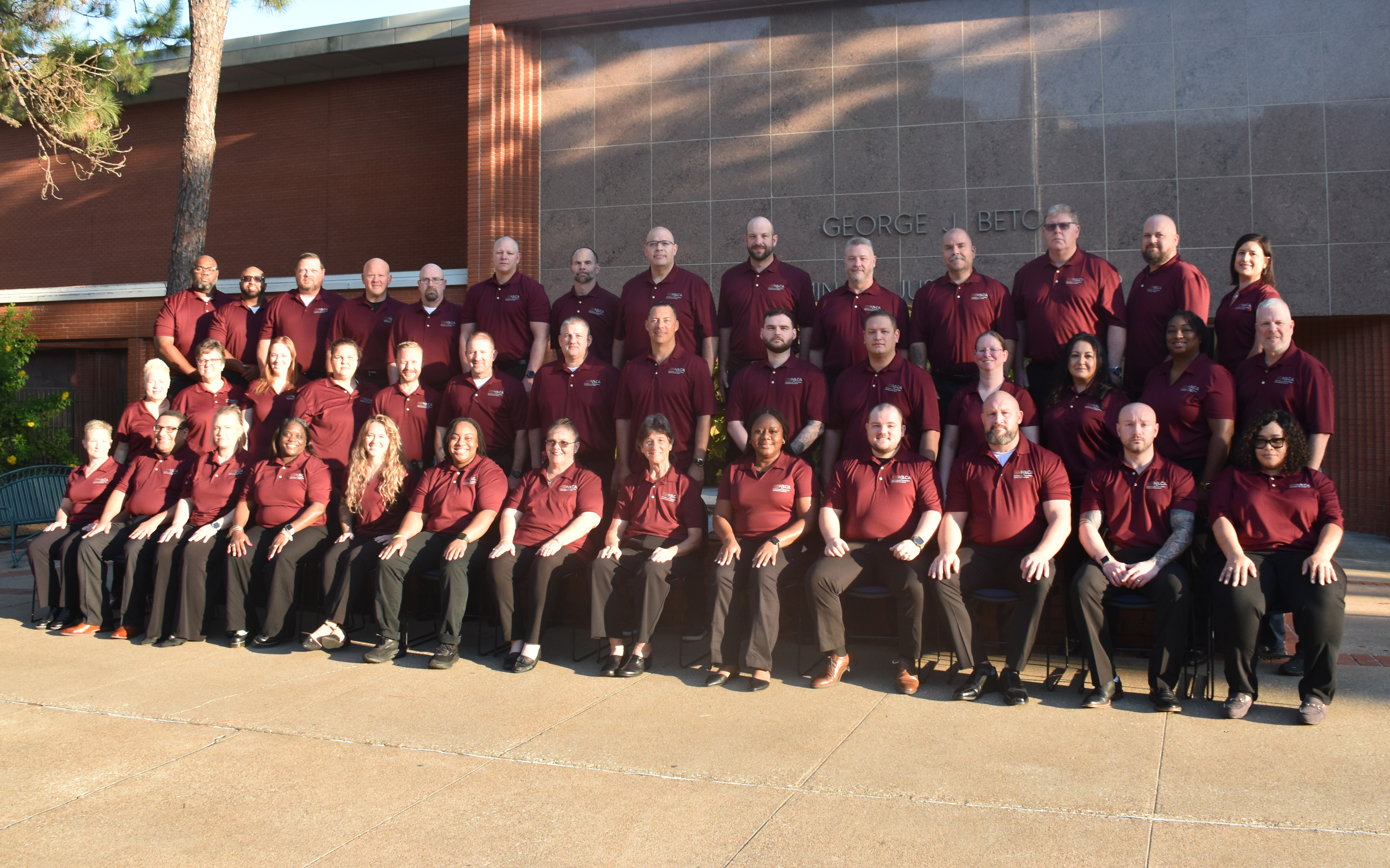 Image: Class #57 grouped outside a red brick building.