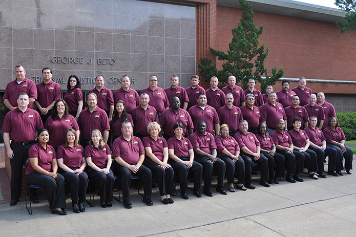 Image: Class #7 grouped outside a red brick building.
